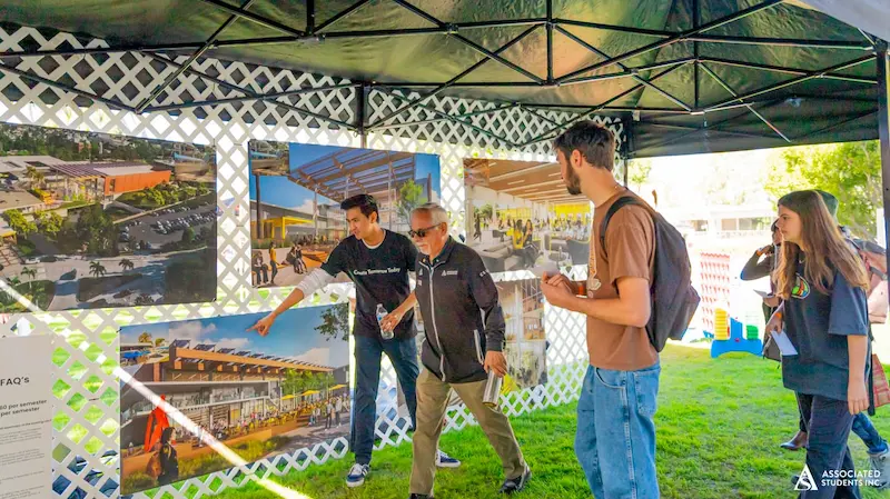 Student and Staff looking at designs